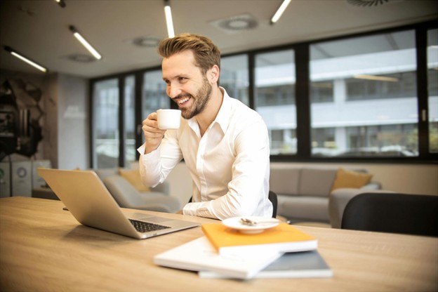 Man at his laptop drinking from a teacup